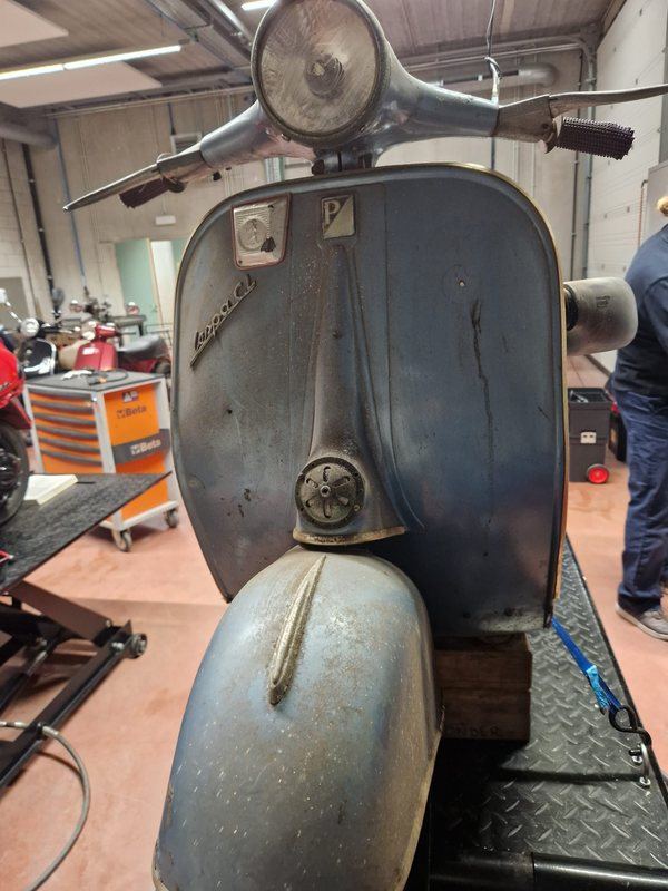 Ongerestaureerde Vespa GL met doffe verf en stof, op de hefbrug in de werkplaats